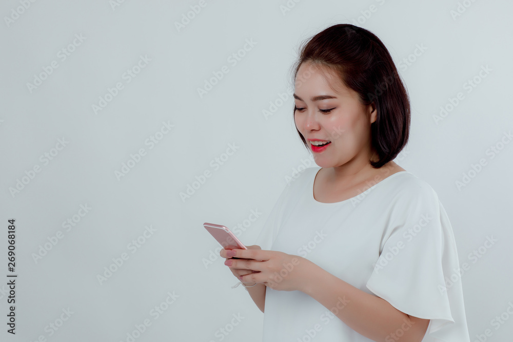 Asian beautiful woman Standing in a white shirt Mobile phone stand press Prepare to make a call. With a happy smile With a white background Asian beautiful woman Standing in a white shirt Mobile phone stand press Prepare to make a call. With a happy smile With a white background