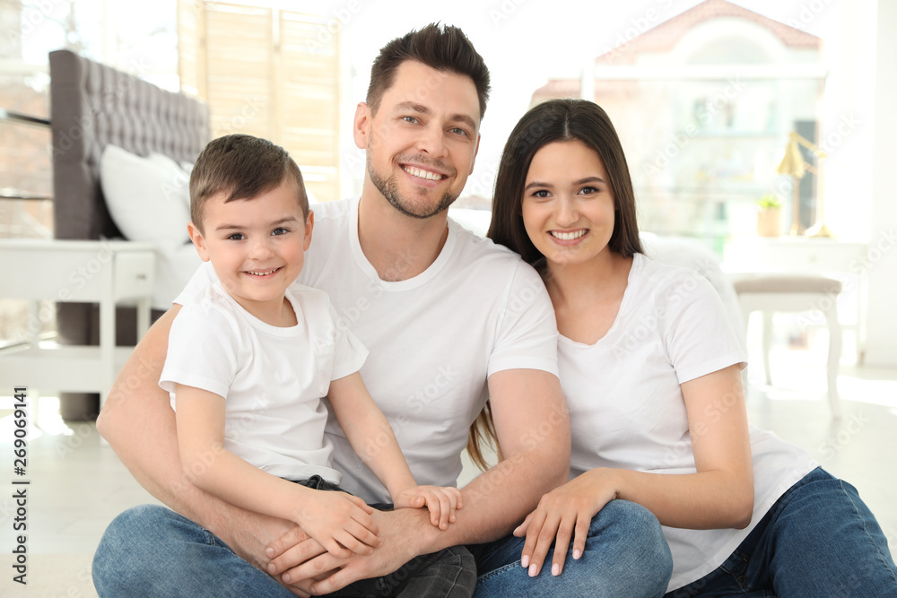 Happy parents and their son sitting together on floor at home. Family time Happy parents and their son sitting together on floor at home. Family time