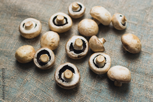 Raw champignons mushroom on burlap background