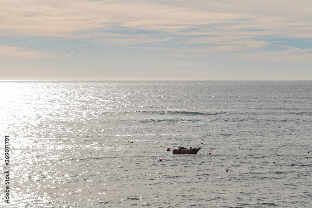 barca solitaria en la costa al atardecer