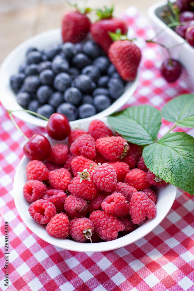 Juicy and delicious raspberries and blueberry in bowl, organic fruit berries Juicy and delicious raspberries and blueberry in bowl, organic fruit berries