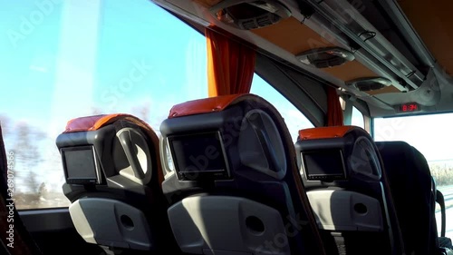 4K view of the empty passenger seats with monitors in a moving bus
