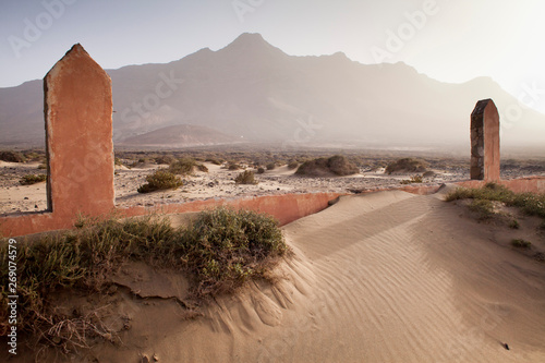 Сhristian Graveyard with abondend cemetery gate on sand dunes at Cofete beach during sunset, Fuerteventura, Canary Islands, Spain. photo