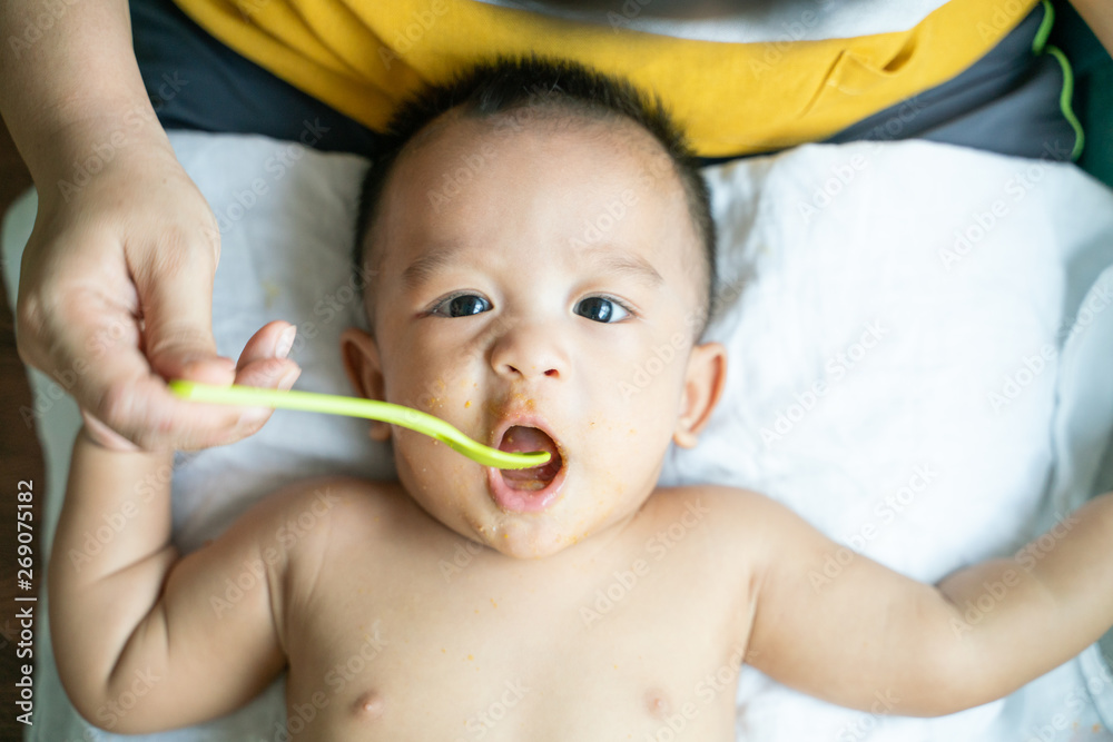 Toddler child boy try to eat pap food by hand of mom Toddler child boy try to eat pap food by hand of mom