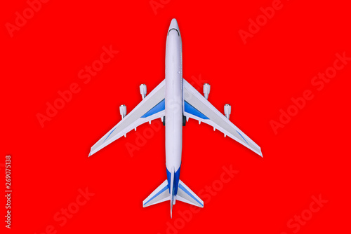 Passenger aircraft on a red background. Summer holidays and air travel concept. Tourism and travel background. Buying or booking online tickets. Business flights