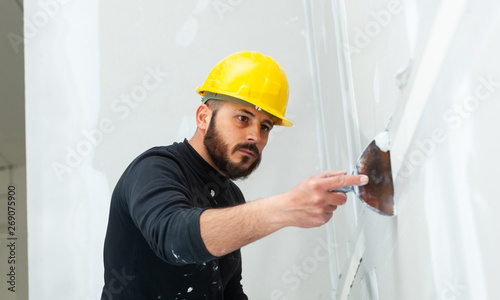 Obraz na płótnie worker plastering gypsum board wall.