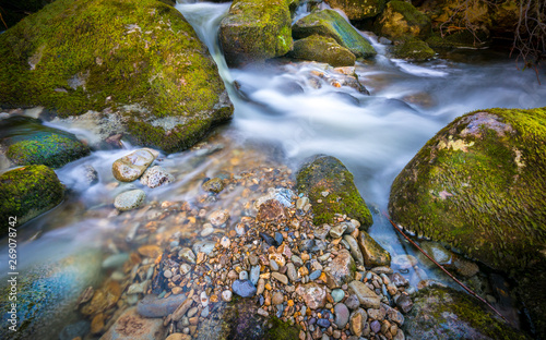 Small Stones at stream edge detail with flowing water