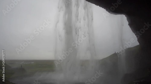 Beautiful Iceland Waterfall with cloudy skies and rocks and grass
