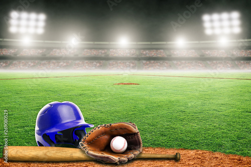 Baseball Helmet, Bat, Glove and Ball on Field in Outdoor Stadium With Copy Space