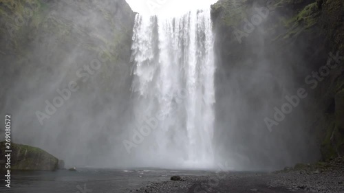 Beautiful Iceland Waterfall with cloudy skies and rocks and grass