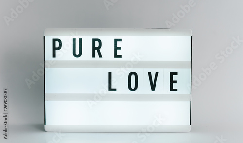 Light box with the headline PURE LOVE with copyspace, over white background photo