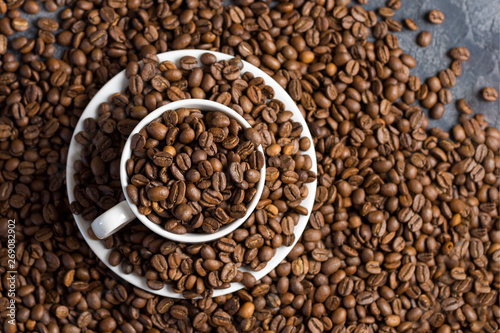 White Cup of coffee with coffee beans . Scattered coffee beans