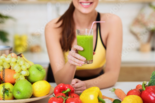 Happy Woman Drinking Fresh Green Detox Vegetable Juice photo