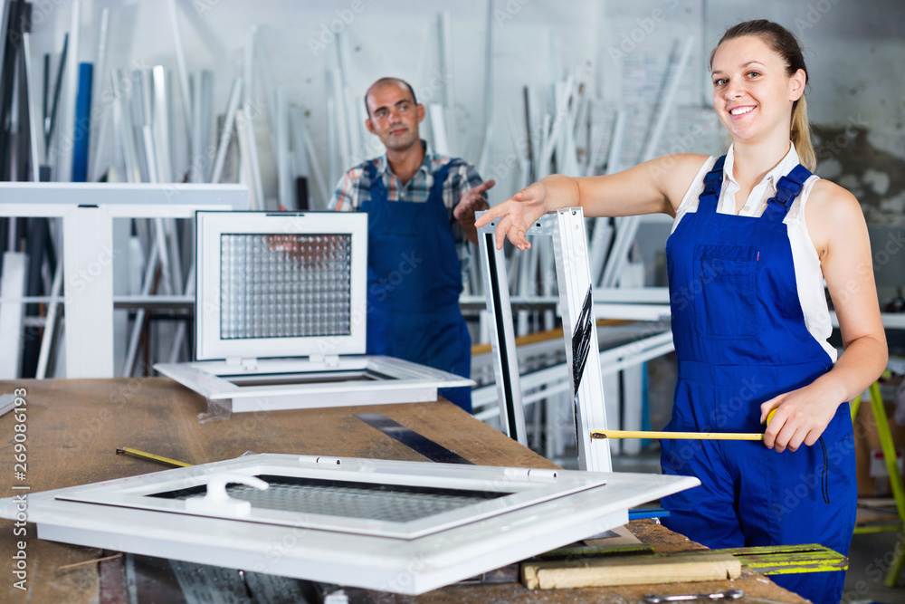 Obraz premium Girl working in workshop for assembling plastic windows