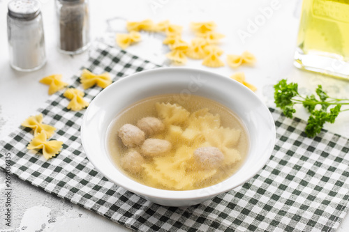 Chicken bouillon with meatballs and farfalle