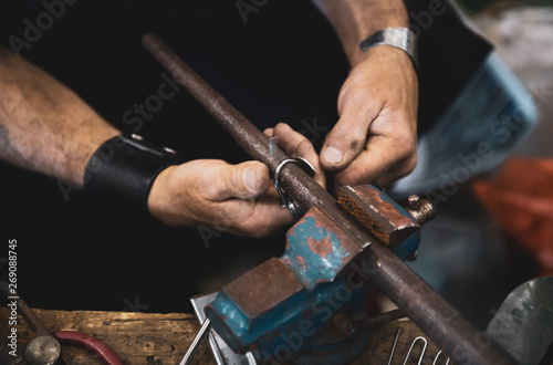 Carpenter man hands at work with hammer and steel