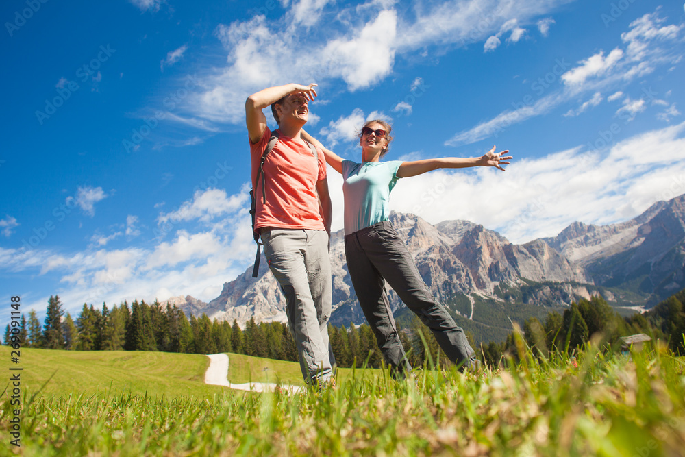 Travelers hiking in breathtaking landscape of Dolomites Mounatins in summer in ALta Badia, Italy. Travelers hiking in breathtaking landscape of Dolomites Mounatins in summer in ALta Badia, Italy.