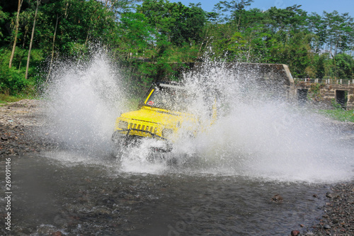 Extreme offroad car through water on the river so as to create sparks at Merapi Mountain Yogyakarta - Indonesia, Asia