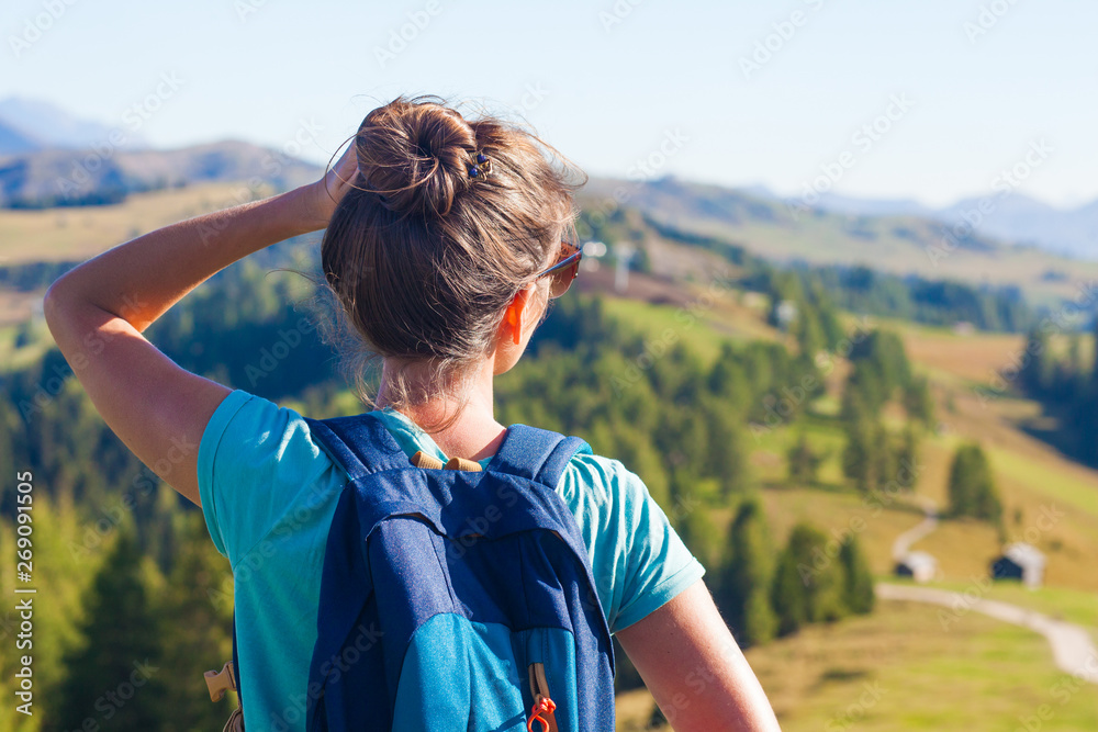 Young woman with backpack hiking at Alta Badia, Dolomites, Italy Young woman with backpack hiking at Alta Badia, Dolomites, Italy