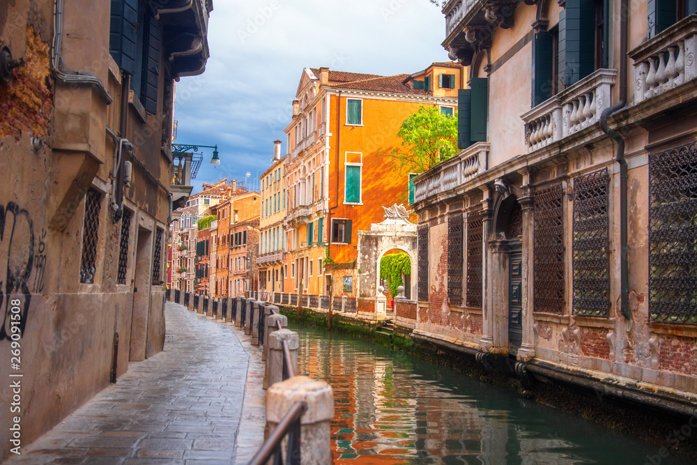 Venice street along canal, Italy. Venezia cityscape. Beautiful Venice