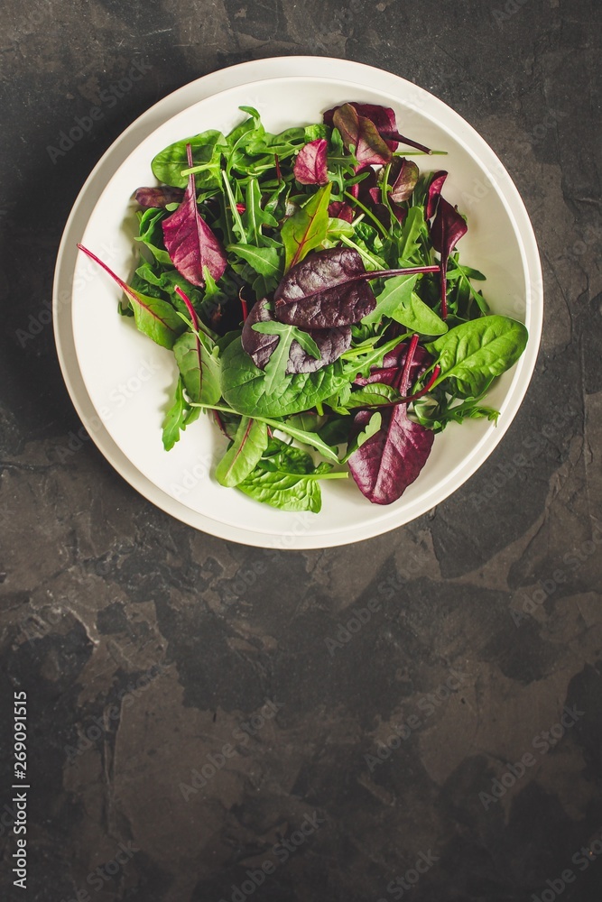 mix lettuce leaves salad in a plate (fresh green snack). food background. top mix lettuce leaves salad in a plate (fresh green snack). food background. top