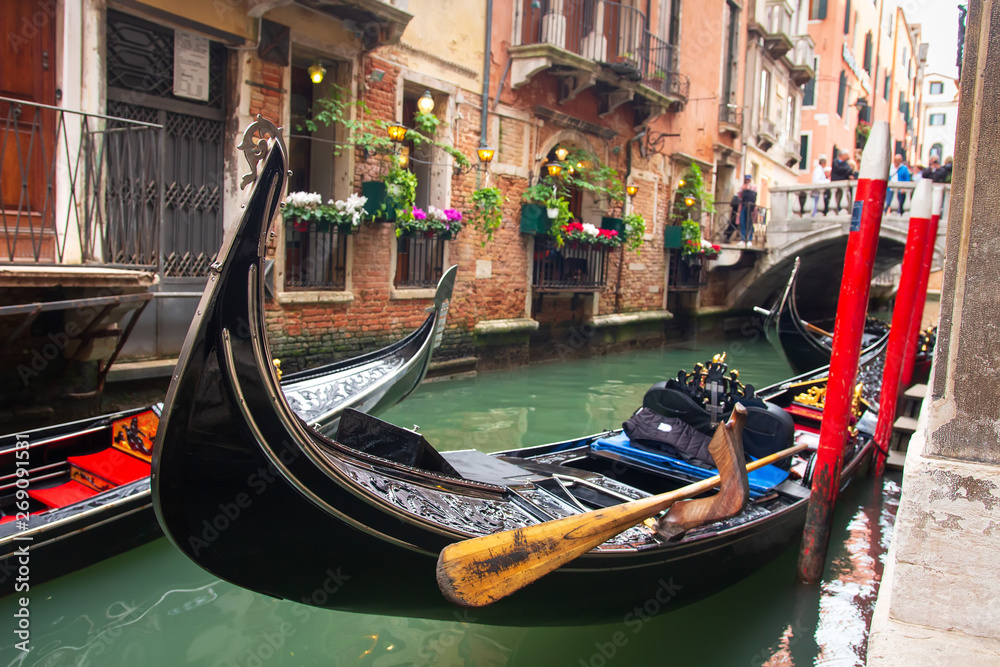 Traditional gondola in venetian water canal in Venice, Italy. Black gondola in Venezia