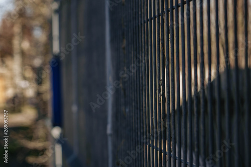 Steel grating fence of soccer field Metal fence wire with grass in the background.