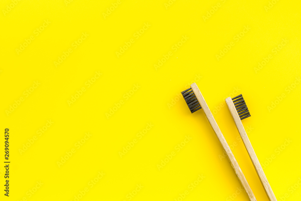Dental care with eco friendly bamboo tooth brush on yellow background top view space for text