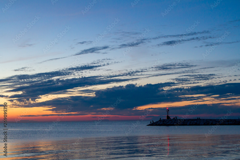 Seascape at sunset. Lighthouse on the coast
