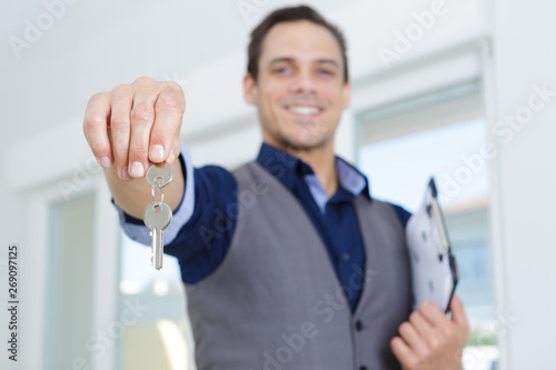 sale man giving a house key after sign loan agreement photo