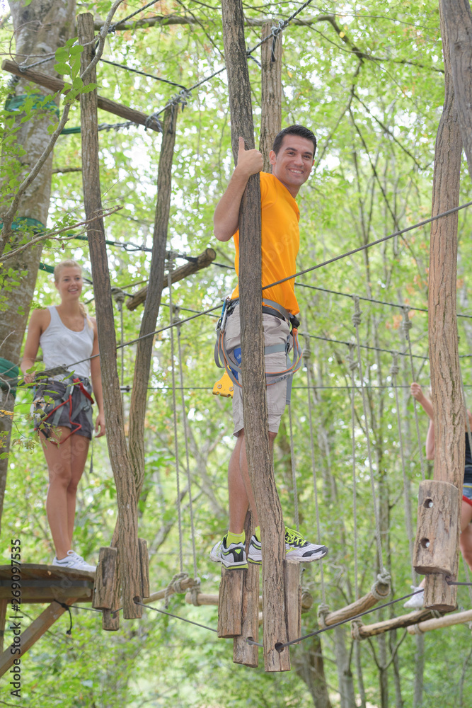 Obraz premium couple on a rope climbing in the adventure park