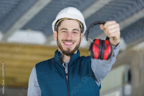 attractive and confident constructor showing ear protection gear