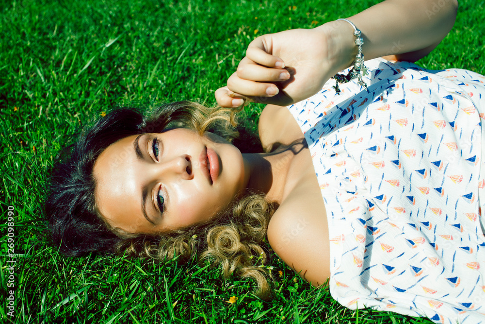 young pretty curly girl smiling cheerful on green grass, lifestyle people concept young pretty curly girl smiling cheerful on green grass, lifestyle people concept