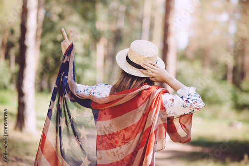 Beautiful patriot woman with american flag show victory sign, USA independent day