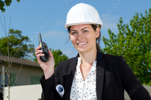 architect woman with helmet holding a walkie-talky photo