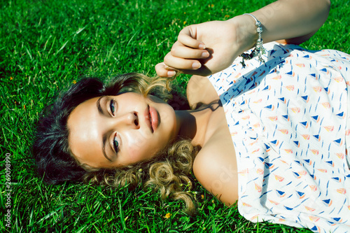 young pretty curly girl smiling cheerful on green grass, lifestyle people concept