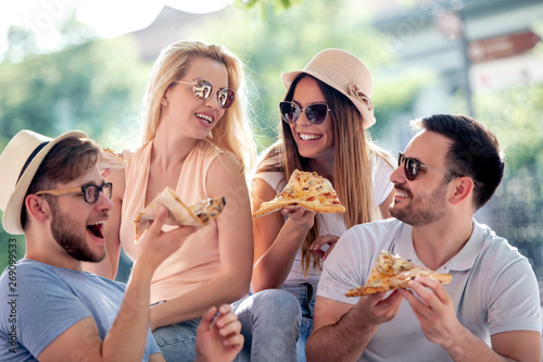 Cheerful friends eating pizza together