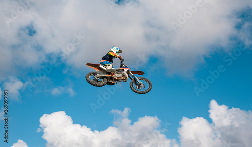 A picture of a biker making a stunt and jumps in the air