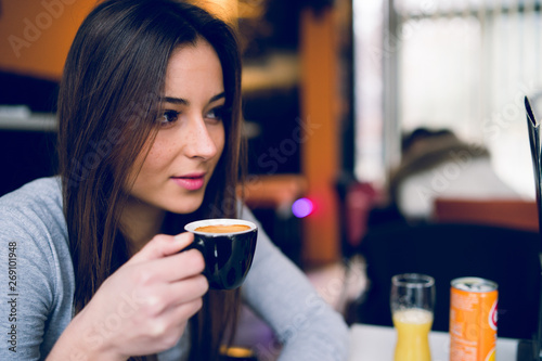 Young teenage woman with cup of coffee at the cafe