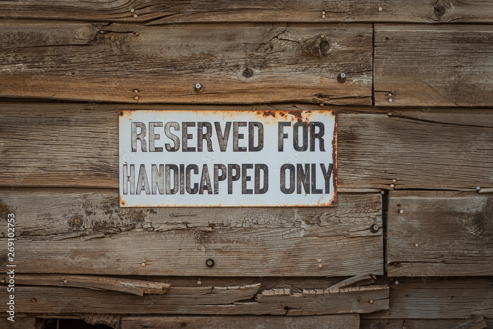 Fototapeta premium An old and weathered handicapped only parking sign