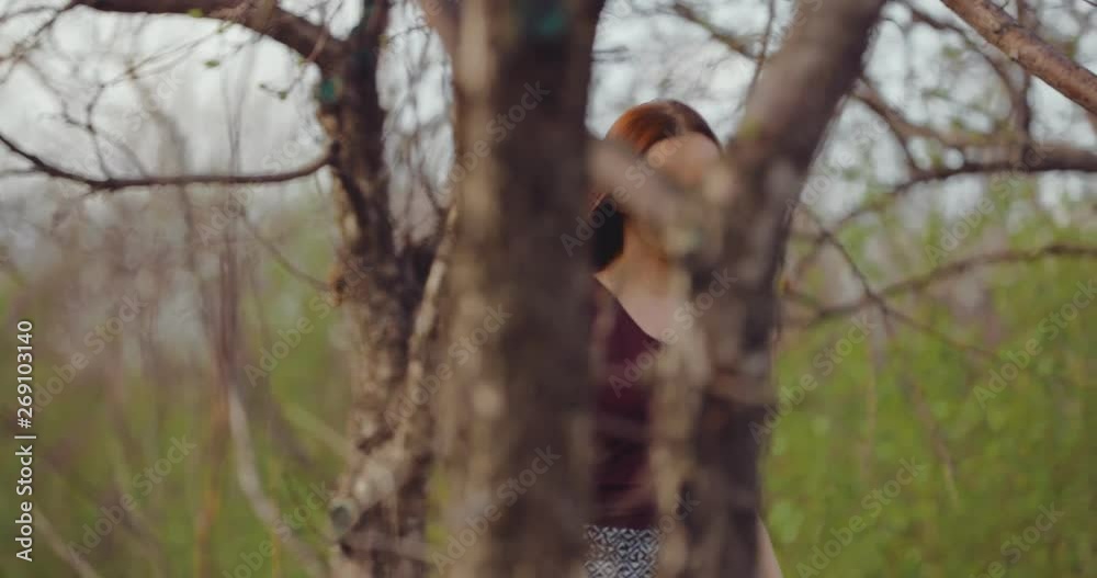 Young beautiful woman walking on a sunny spring day among the trees. Girl is happy, early spring, the trees bloom. Young beautiful woman walking on a sunny spring day among the trees. Girl is happy, early spring, the trees bloom.