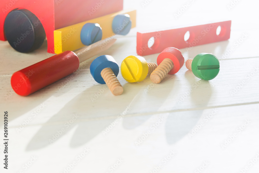 Car wooden constructor for preschool education. Children's activity with screwdriver and screws. Baby skills concept