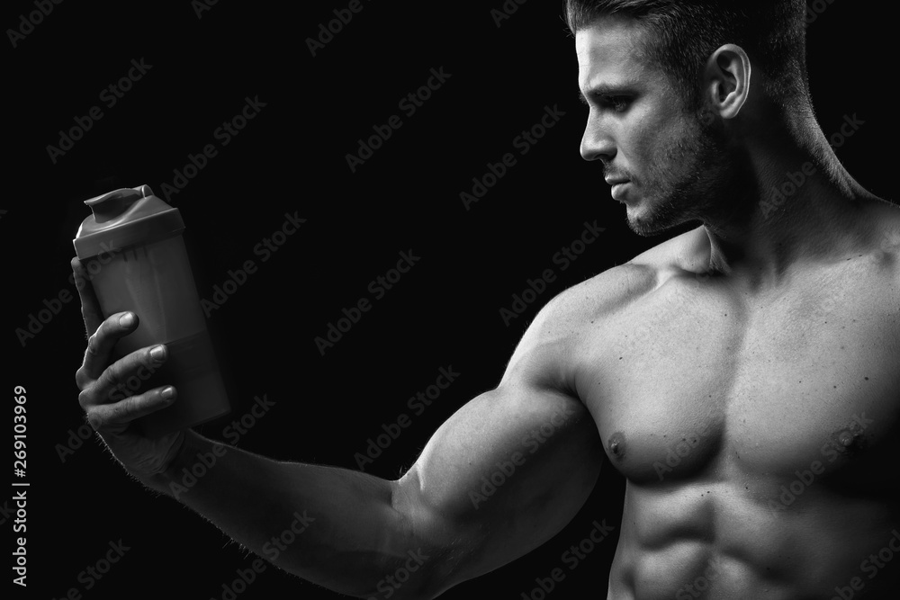 Model sports young man on dark background. Black and white portrait of muscle  guy with protein drink in shaker. Bodybuilding nutrition supplements,  sport, workout, healthy lifestyle concept. Stock Photo | Adobe Stock