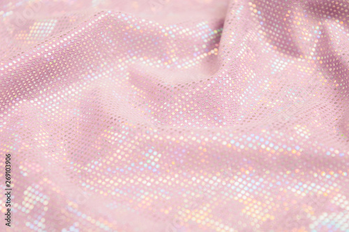 Pink shiny fabric textured background. Textile backdrop with waves. Selective focus