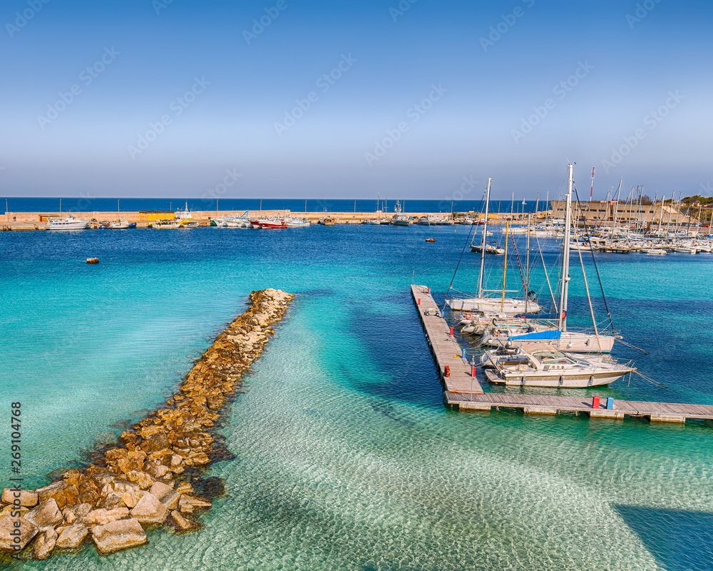 Several fishing boats at the Otranto harbour - coastal town in Puglia with turquoise sea