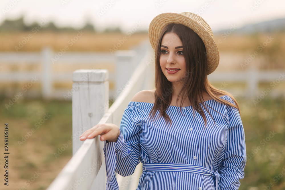 Beautiful portrait of cheerful pregnant woman in blue dress and knitted hat. Lady smile