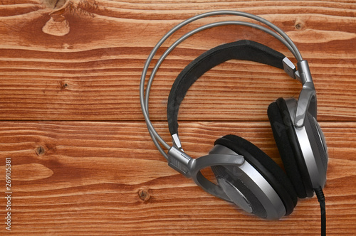 Vintage headphones for listening to sound and music on a wooden background