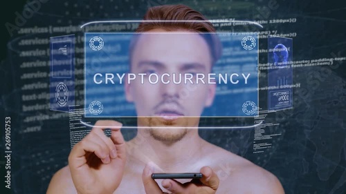 Young man interacts with a conceptual HUD hologram with text Cryptocurrency exchange. Guy with future technology mobile screen on background of the program code photo