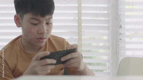 Asian boy playing on smart phone at home . Timelaps .