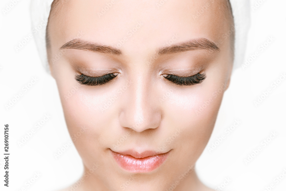 Eyelash extension procedure. Beautiful woman with long eyelashes. Facial treatment. Cosmetology, beauty skin care and spa concept. Isolated on white background. Permanent makeup. Microblading brow.